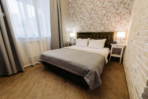 斯摩棱斯克的住宿－City Hotel，一间卧室配有一张带两张桌子和两盏灯的床。
