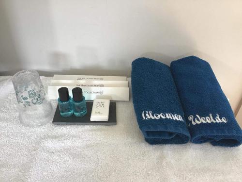 a pair of towels and a pair of shoes on a bed at B&B Bloemenweelde in Kortrijk