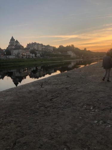 a person walking along a river at sunset at Grand gite en rez-de-jardin in Saint-Aignan
