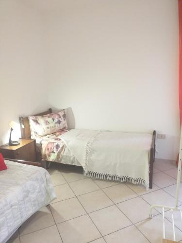a bedroom with two beds and a tiled floor at B&B Las Vegan in Cles