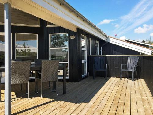 a deck with a table and chairs on a house at 6 person holiday home in R nde in Rønde