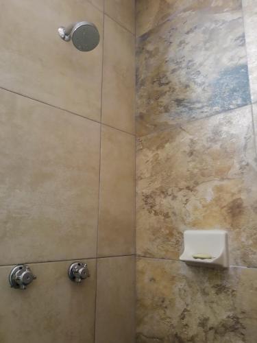 a bathroom with a shower with a soap holder at Hostal en El Centro LaKiwa in Mazatlán