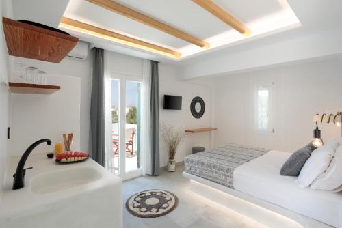 a white bedroom with a bed and a bath tub at Iades Studios & Apartments in Agia Anna Naxos