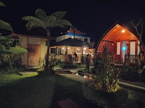 a man standing outside of a house at night at Umah lumbung bedugul in Bedugul