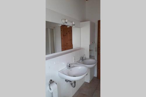 a bathroom with two sinks and a mirror at Ferienwohnung in Seenähe in Borgdorf-Seedorf