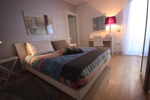 a bedroom with a bed with a colorful blanket on it at La Lanterna in Padova