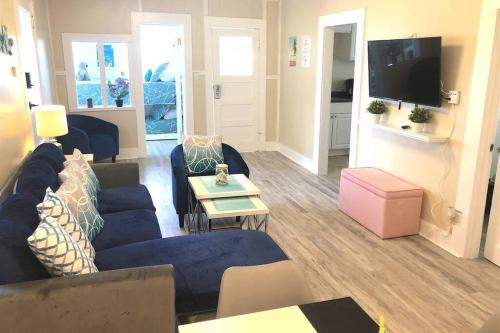 a living room with a blue couch and a tv at CasaViva Play - 3BR 1BA, Private Deck & City Views, Firepit, Kids Playset - Walk to Hillcrest & North Park, Near Zoo, SeaWorld & Beaches in San Diego