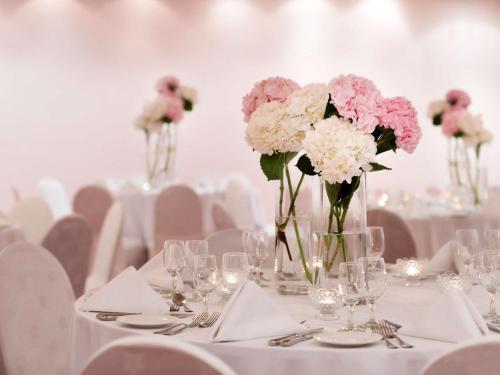 a table with vases filled with pink and white flowers at Treffen House Doha - Souq Waqif and next to Msheireb Metro Station in Doha