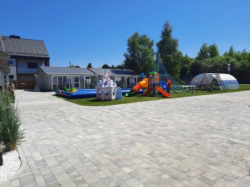 a playground with slides and play equipment in a yard at Holiday Homes 777 in Karwia