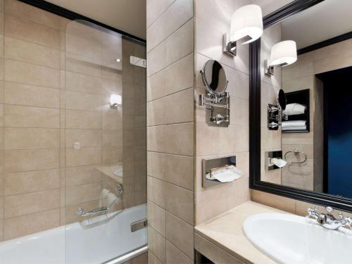 a bathroom with a sink and a mirror at Hotel Rotary Geneva - MGallery in Geneva