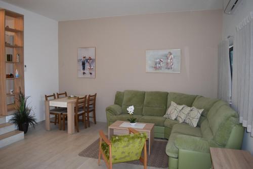 a living room with a green couch and a table at Villa Mio Mare in Cres