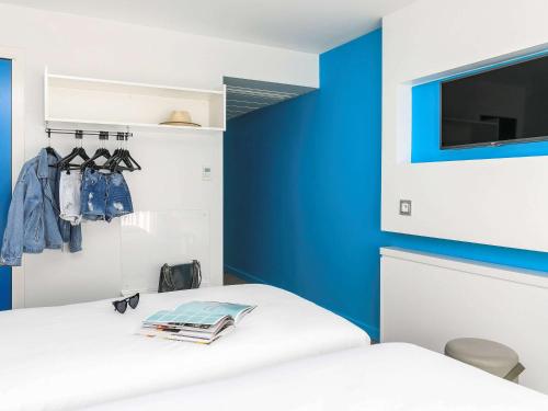 a bedroom with blue and white walls and a bed at Ibis Styles Menton Centre in Menton