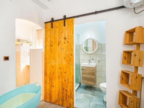 a bathroom with a wooden sliding shower door at Somni in Cullera