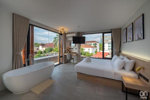 a bedroom with a large bed and a bath tub at ON Thapae Gate Chiangmai in Chiang Mai