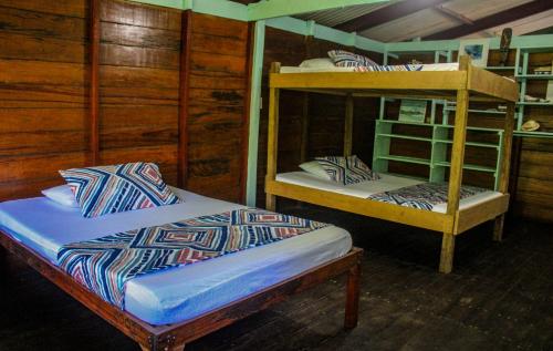 a bedroom with two bunk beds in a cabin at Refugio Mr Jerry Eco House in Bahía Solano