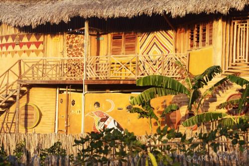 un bâtiment avec une peinture sur son côté dans l'établissement Raízes Eco Hostel, à Barra Grande