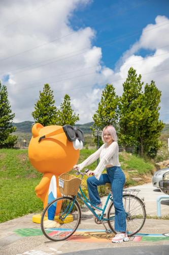 a woman riding a bike next to a bear statue at Lovestar Lakeside Hotel - Starlight Building in Hengchun