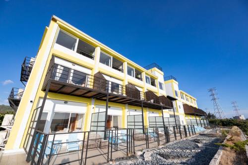 a yellow building with chairs in front of it at Lovestar Lakeside Hotel - Starlight Building in Hengchun
