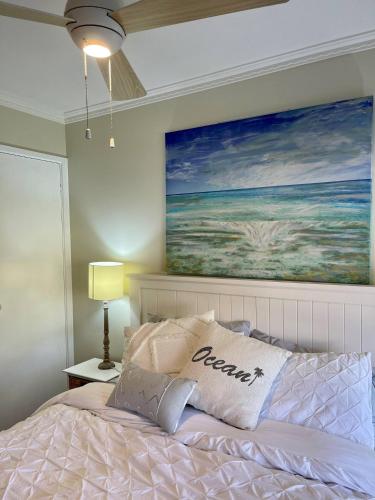 a bedroom with a bed with a painting on the wall at Coastal Country Retreat, Spa, fireplace, pet friendly, FREE WIFI wine & chocolates, Kilarney, 10 minutes to Phillip Island in Kilcunda