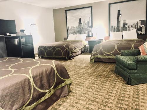 a hotel room with two beds and a chair at Super 8 by Wyndham Peru Starved Rock State Park in Peru