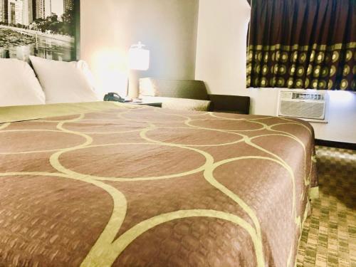 a hotel room with a large bed with a swirl pattern at Super 8 by Wyndham Peru Starved Rock State Park in Peru