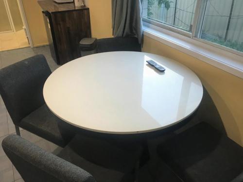 a white table with two chairs and a remote control on it at Toukley Motor Inn in Toukley