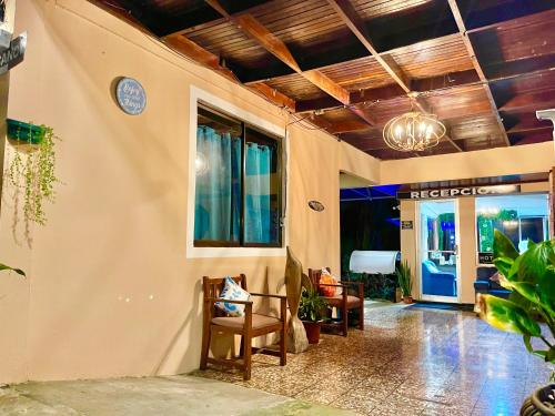 ein Wohnzimmer mit einem Tisch, Stühlen und einer Tür in der Unterkunft Hotel Beachfront Vista Hermosa in Jacó