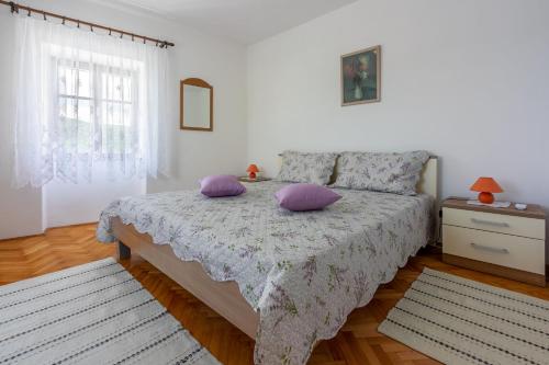 - une chambre avec un lit doté d'oreillers violets dans l'établissement House Katica, à Grižane