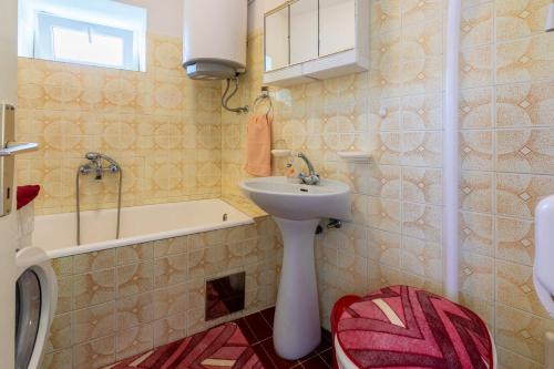 La salle de bains est pourvue d'un lavabo, de toilettes et d'une baignoire. dans l'établissement House Katica, à Grižane