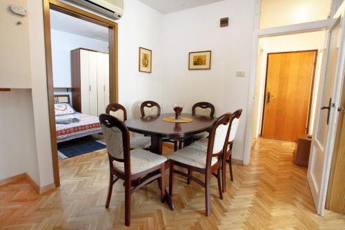 a dining room with a table and chairs and a bedroom at City Center Comfort Blue Sky in Koper