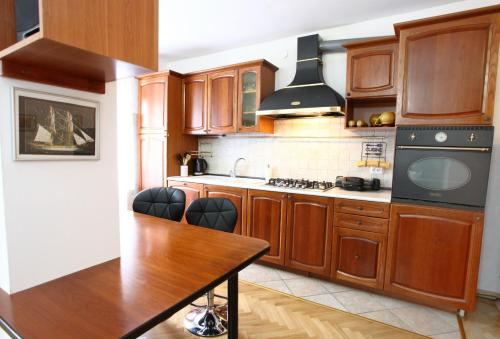 a kitchen with wooden cabinets and a stove top oven at City Center Comfort Blue Sky in Koper