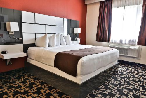 a hotel room with a large bed and a window at Baymont by Wyndham Medicine Hat in Medicine Hat