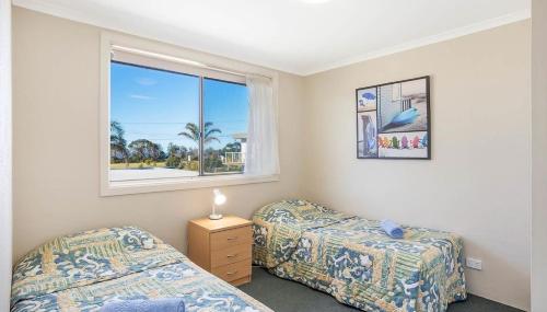 Кровать или кровати в номере Surfside Merimbula Holiday Apartments