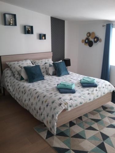 sypialnia z dużym łóżkiem z niebieskimi poduszkami w obiekcie La Salamandre w mieście Le Busseau