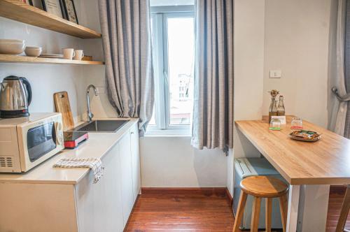 a kitchen with a microwave and a counter with a sink at WECOZY HANOI - Railway Side, The Old Quarter in Hanoi