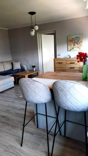 - une cuisine avec une table et deux chaises blanches dans l'établissement Riverside Apartment Pärnu, à Pärnu