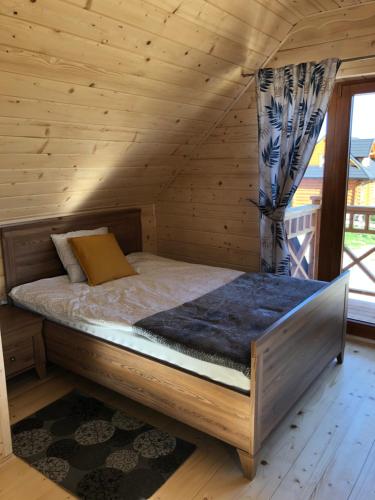 a bedroom with a bed in a log cabin at DOMEK POD LIMBAMI III in Kluszkowce