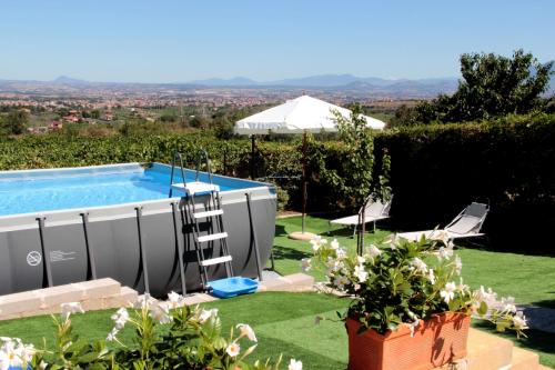 a garden with a swimming pool and a lawn with flowers at Appartamento in Villa Santa Caterina in Frascati