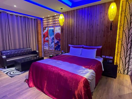 a bedroom with a king sized bed and a couch at Yosemite Motel - Chunghua Branch in Taichung