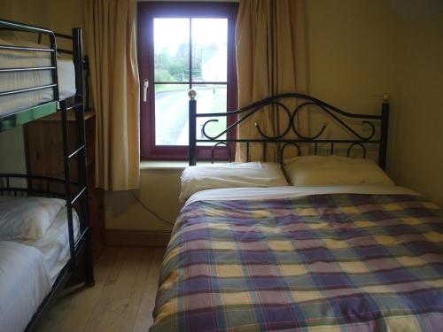 1 Schlafzimmer mit 2 Etagenbetten und einem Fenster in der Unterkunft Brú na Dromoda/Dromid Hostel in Killeenleagh Bridge