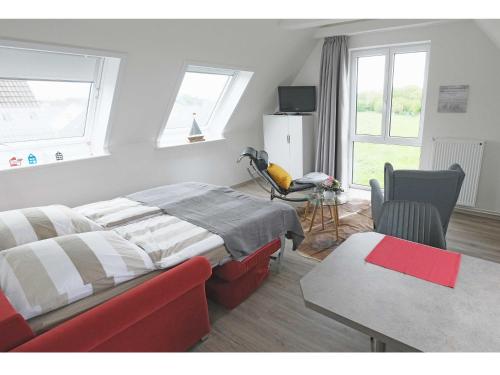 Schlafzimmer mit einem Bett, einem Tisch und einem Fenster in der Unterkunft Appartements Buesum LW28 in Büsum