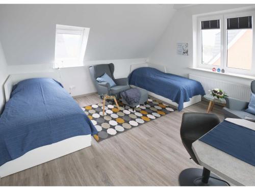 1 Schlafzimmer mit 2 Betten, einem Stuhl und einem Schreibtisch in der Unterkunft Appartements Buesum LW28 in Büsum