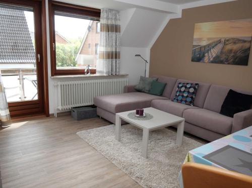 ein Wohnzimmer mit einem Sofa und einem Tisch in der Unterkunft Appartements Buesum LW28 in Büsum