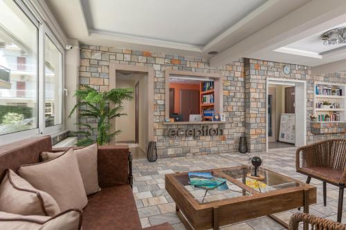 a living room with a couch and a table at Ouzas luxury Hotel in Olympiaki Akti