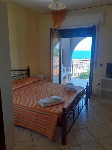a bedroom with a bed with a view of the ocean at Olimpo in Diamante