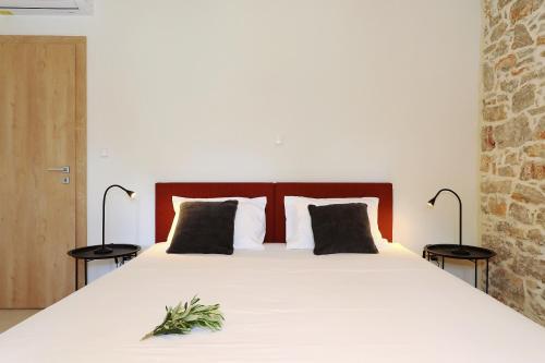 a bedroom with a large white bed with two lamps at Villa Mira with a heated pool and a sea view in Božava