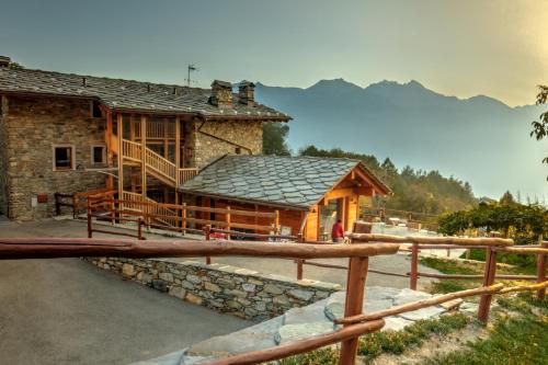 a log cabin with a porch and a fence at Maison Perriere - Chambres d'hôtes & Jacuzzi in Saint Vincent