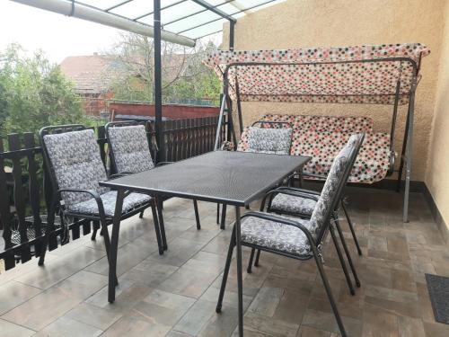 a black table and chairs on a patio at Arany apartman Zsóry in Mezőkövesd