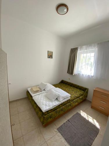 1 dormitorio con 1 cama con sábanas blancas y ventana en Luxury apartman en Balatonkenese