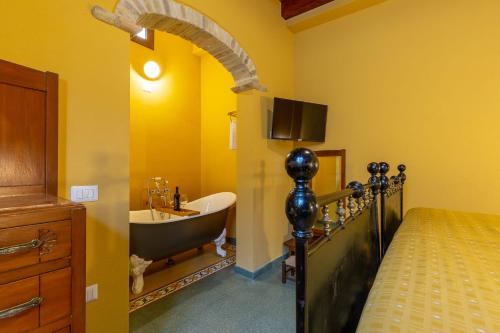 a bathroom with a tub and a sink and a bed at B&B ANTICA KALAGONIS in Maracalagonis